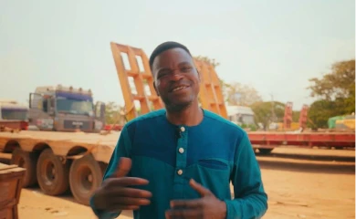 Savior Dzikunu in front of transport equipment